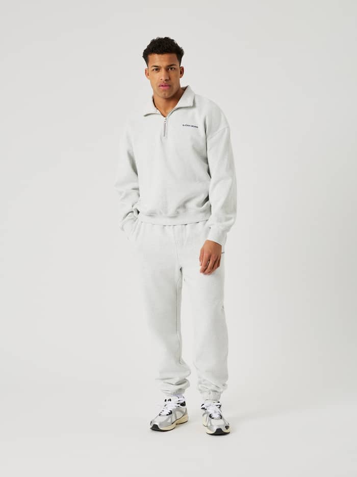 Volledig vooraanzicht van een man in de Borg Oversized Sweatpants in Ultra Light Grey Melange (Grijs) met tennisdetails. - Image 3