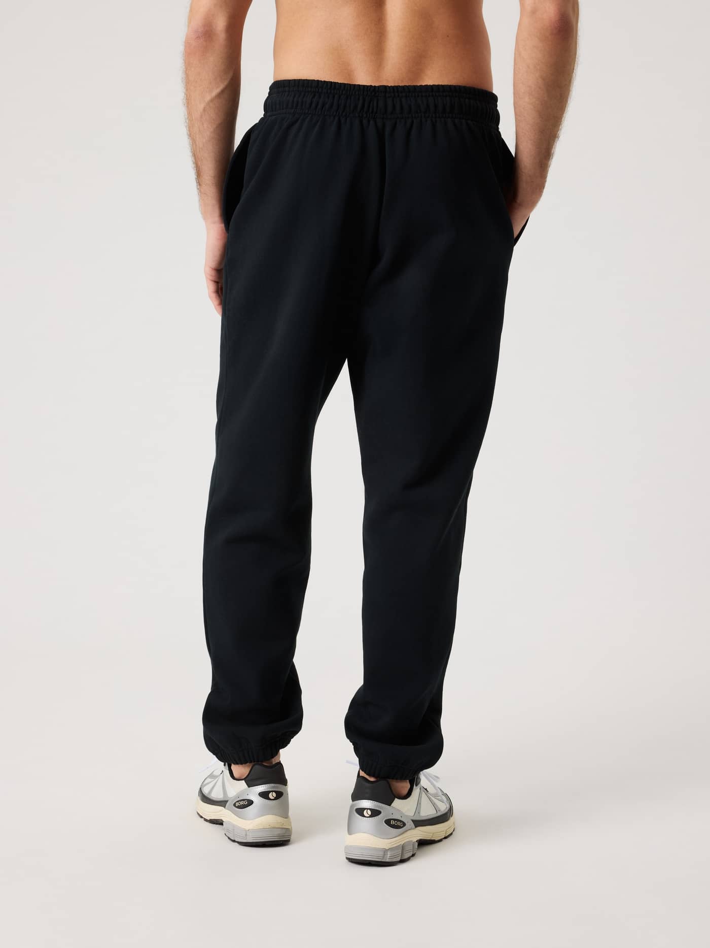 Back view of a man wearing the Borg Oversized Sweatpants in Black Beauty (Black), featuring a tennis print and relaxed fit. - Image 2