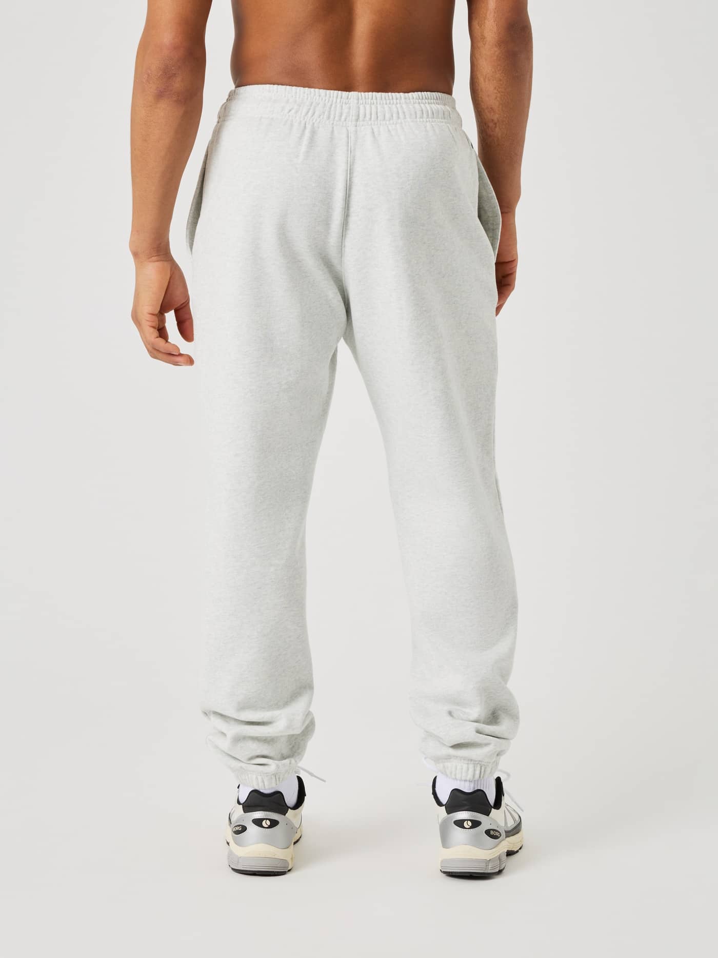 Back view of a man wearing the Borg Oversized Sweatpants in Ultra Light Grey Melange (Grey) with a relaxed, modern fit. - Image 2