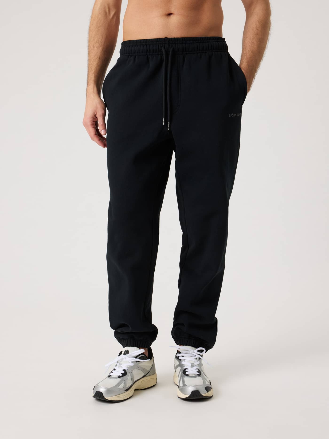 Front view of a man wearing the Borg Oversized Sweatpants in Black Beauty (Black) for a relaxed, tennis-inspired fit. - Image 1