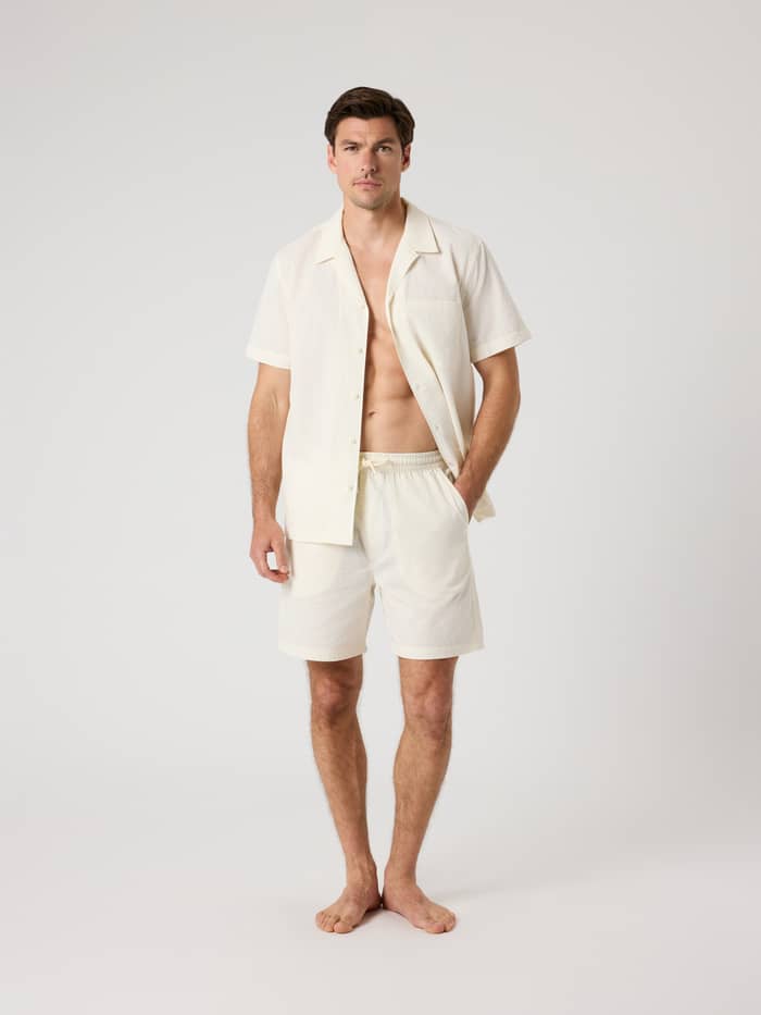 Volledig vooraanzicht van een man in de Borg Seersucker Resort Shorts in Tofu (Wit) met een stijlvolle structuur. - Image 3