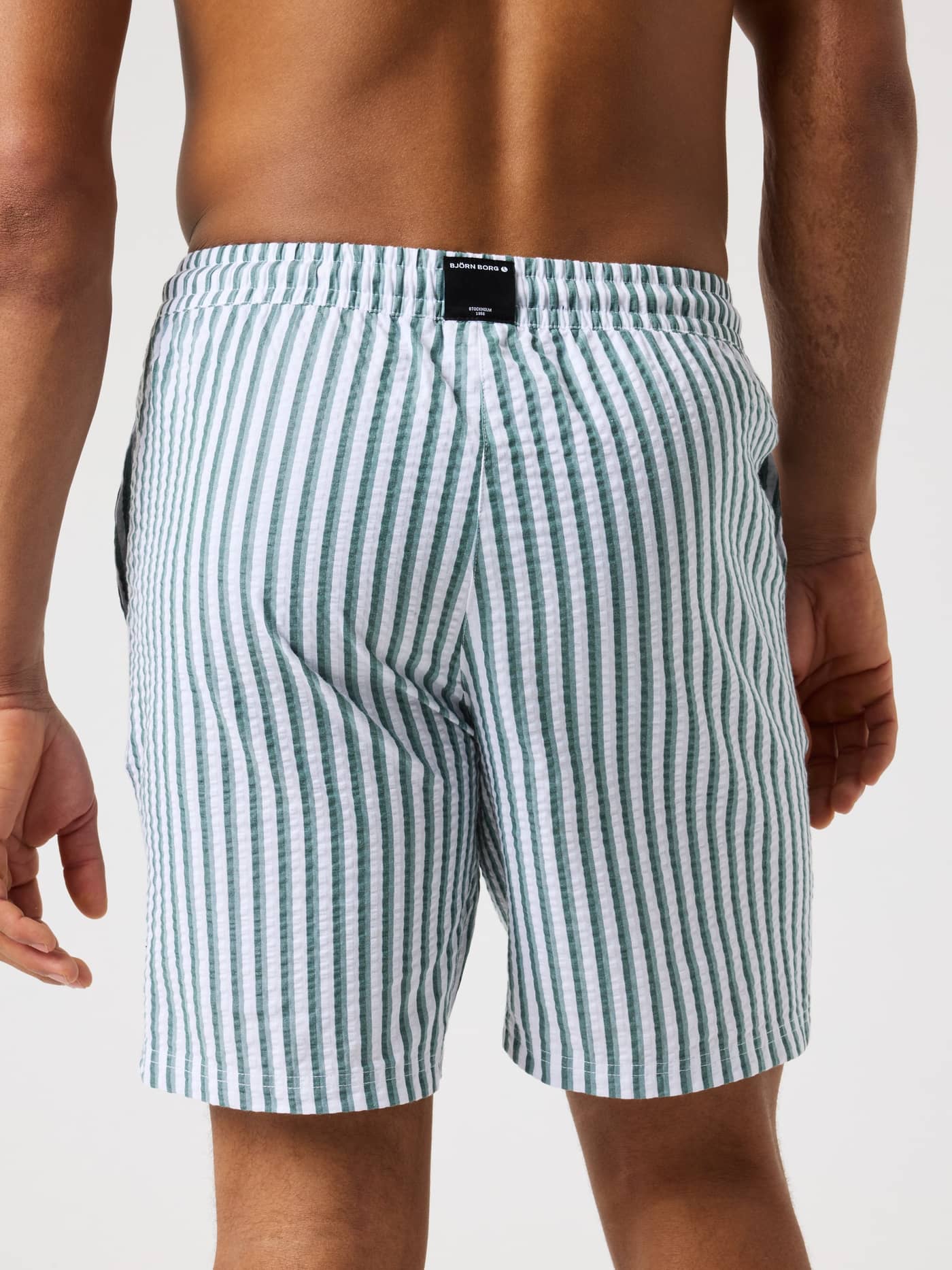 Vista posterior de los Borg Seersucker Resort Shorts en 7 Stripe 1 (Verde/Blanco) a rayas con etiqueta de logo negra. - Image 2