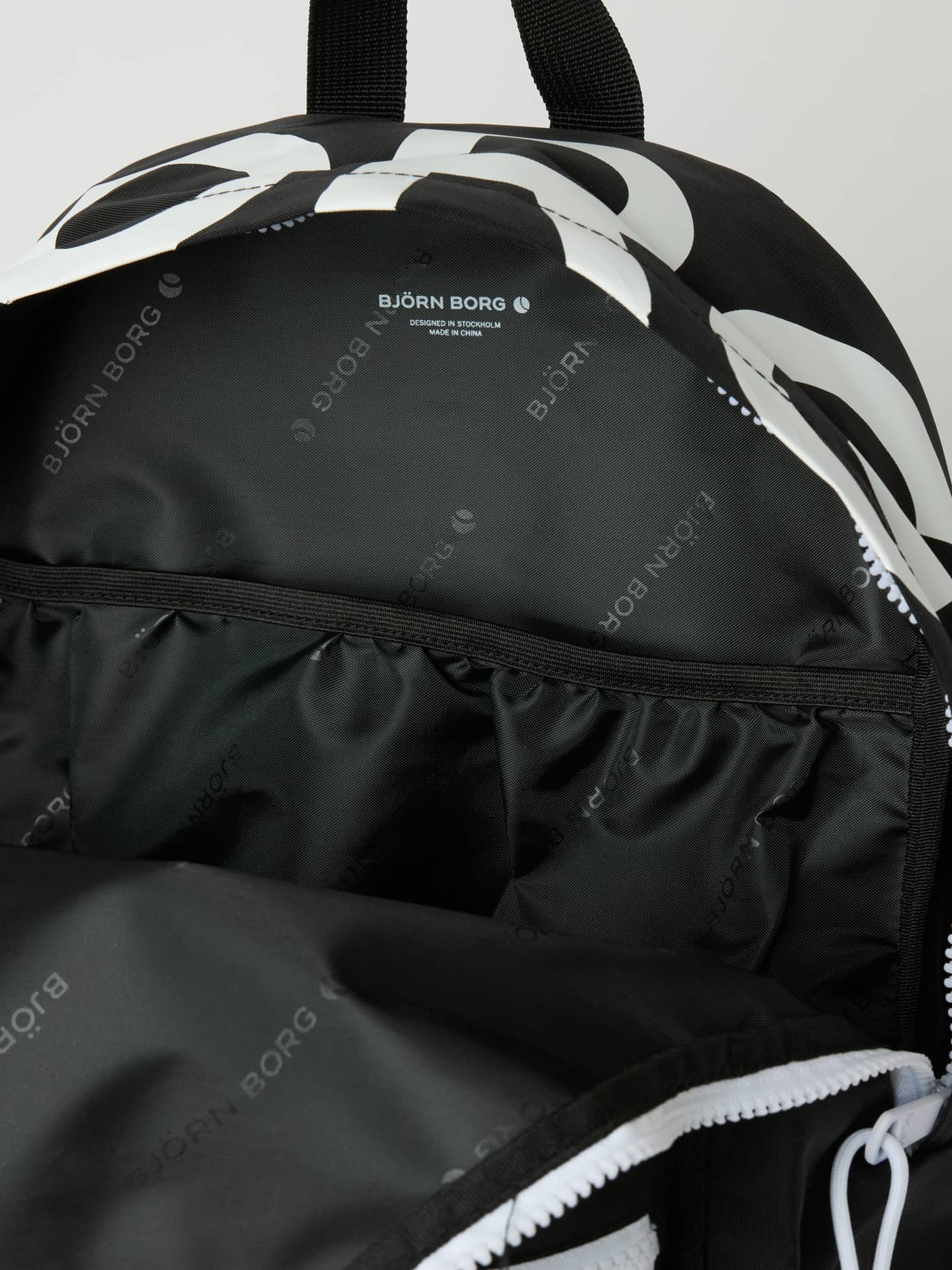 Close-up of the Borg Logo Backpack 27L in Black Beauty (Black), featuring white branding and a logo-printed interior. - Image 4