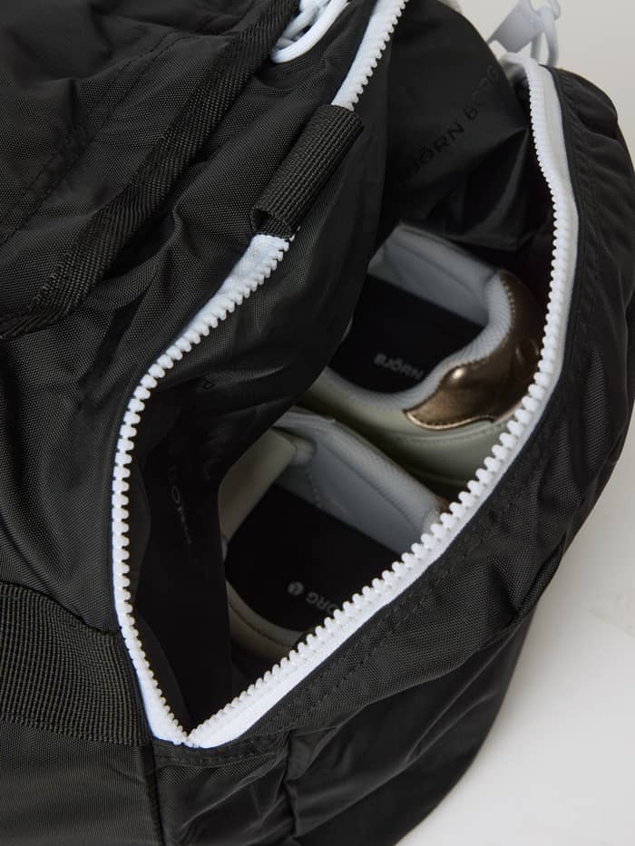 Detailed side pocket of the Black Beauty (Black) Borg Logo Sports Bag 42L, featuring a white zipper and training shoes.