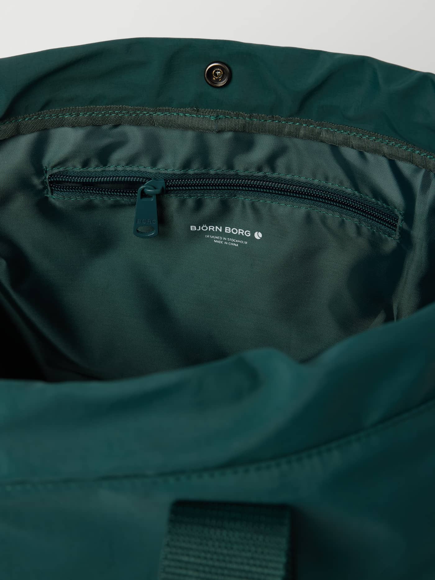 Interiør av Studio Active Tote 23L i Mallard Green (Grønn) med glidelåslomme og trykknapp for treningsutstyr. - Image 3