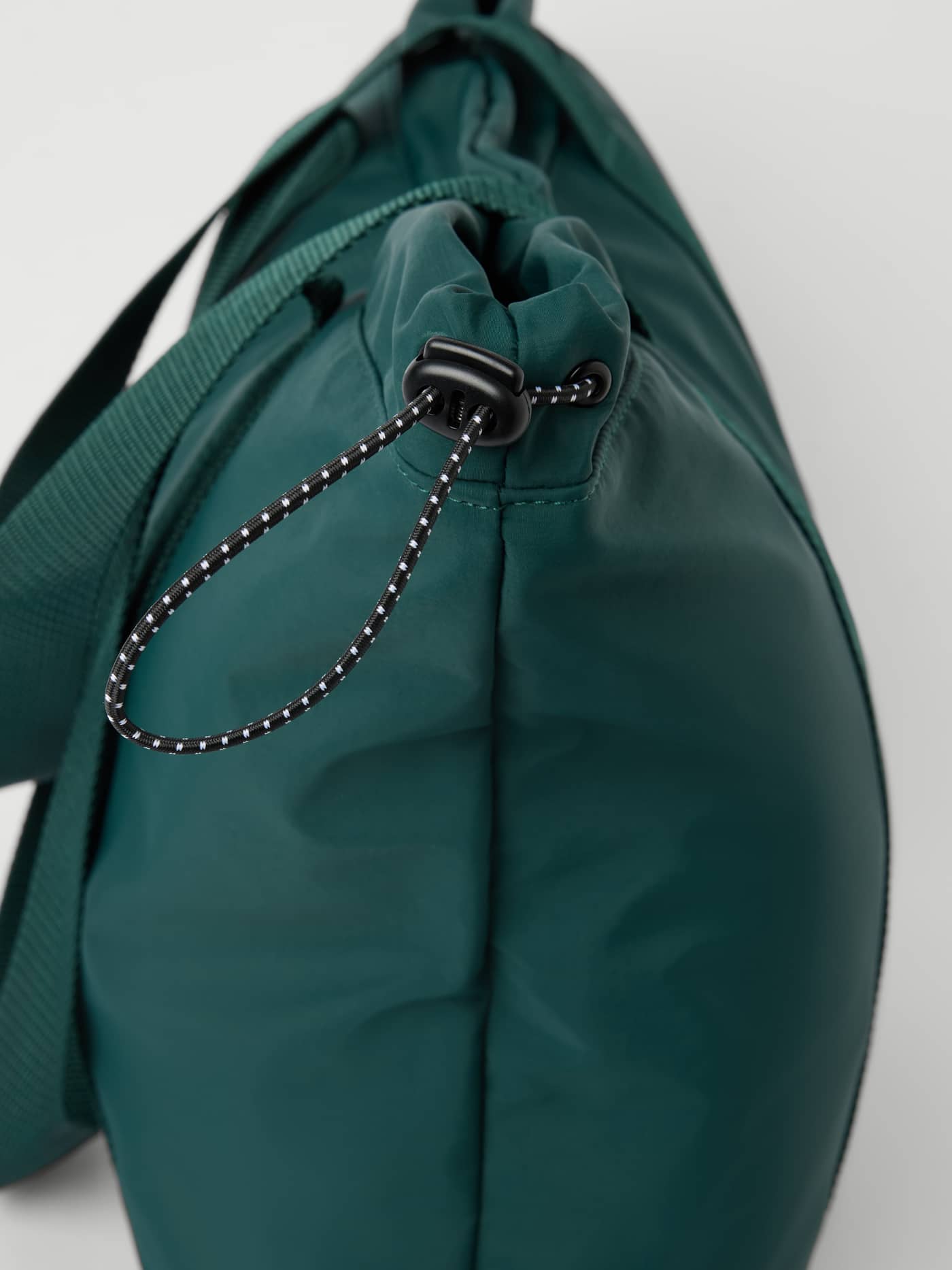 Studio Active Tote 23L i Mallard Green (Grønn) med spraglete justerbar trekksnor og svart snorlås i siden. - Image 4