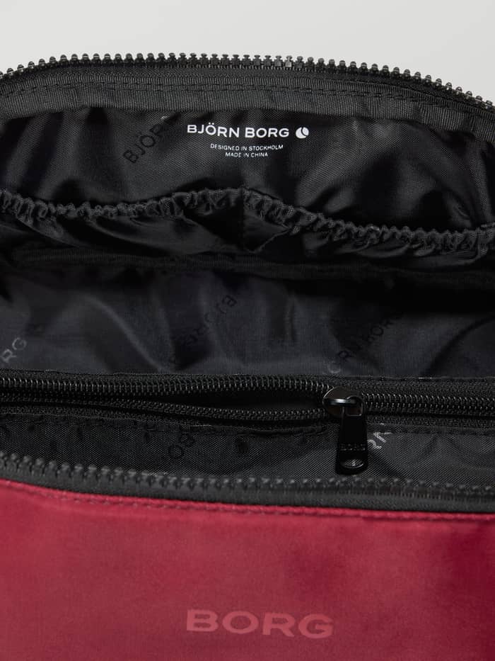 Binnenkant van de Borg Classic Wash Bag in Cabernet (Rood) met binnenvakken en wit logo voor training. - Image 3