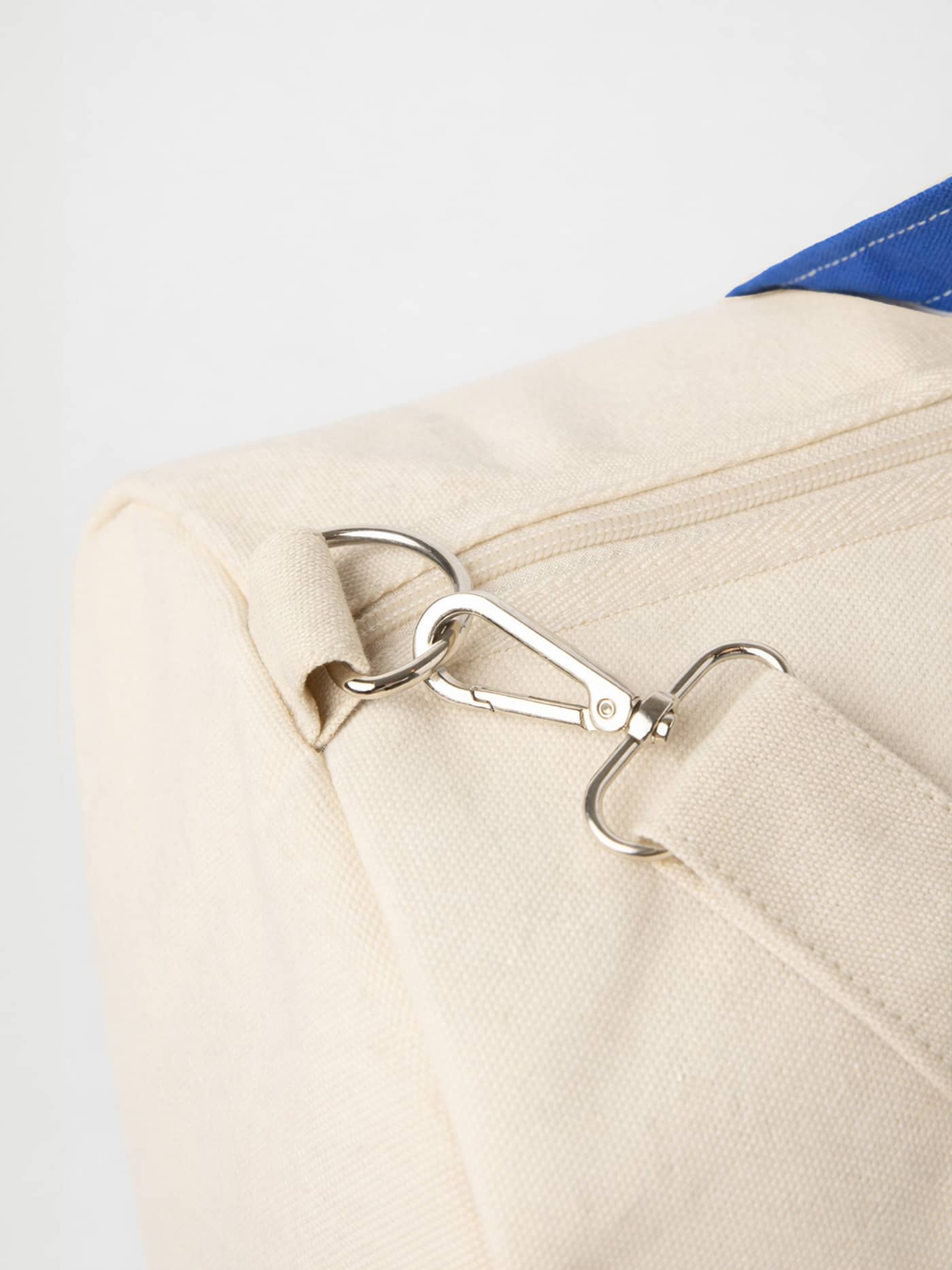 Detail view of the silver metal clasp on the Ace Canvas Sports Bag 38L in Egret (White) for tennis and gym training. - Image 3