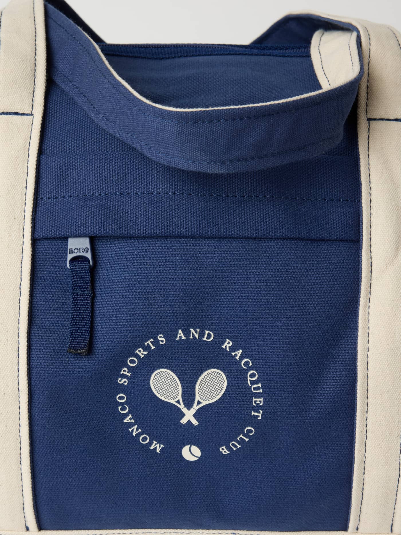 Close-up of the cotton canvas Ace Canvas Sports Bag 40L in Blue Depths (Blue) featuring a white tennis club logo. - Image 4