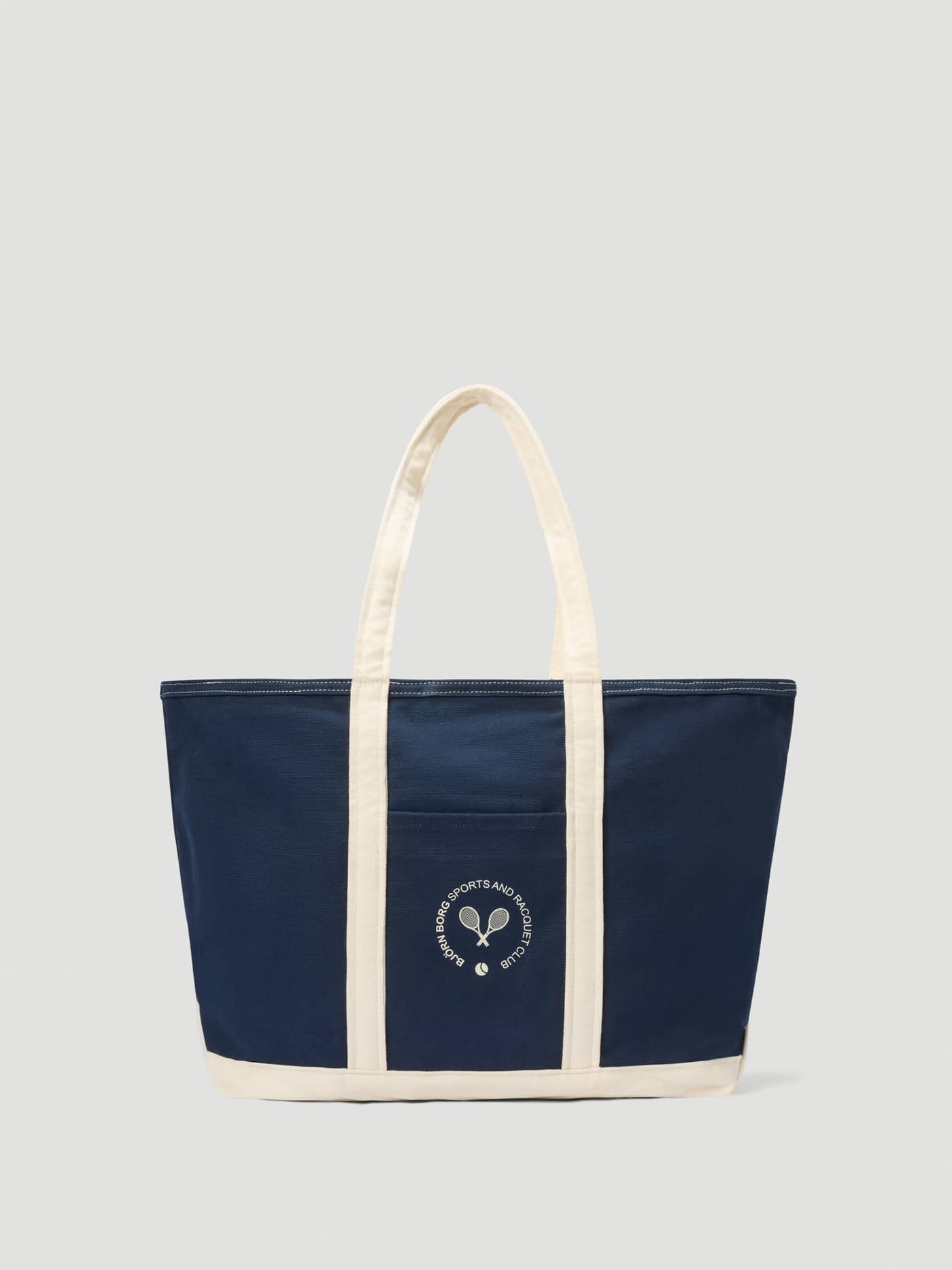 Ace Canvas Tote 27L in Night Sky (Navy) featuring durable cotton canvas and a signature tennis club graphic. - Image 1