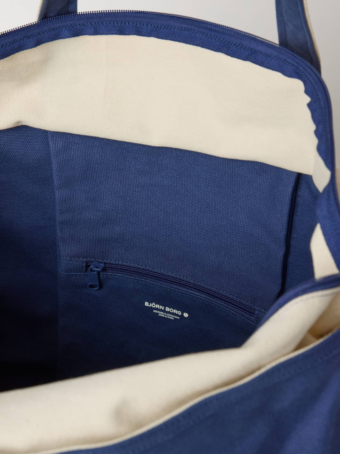 Ace Canvas Tote 30L in Blue Depths (Blauw) met een binnenvak met rits voor georganiseerde tennisopslag, binnenaanzicht. - Image 5