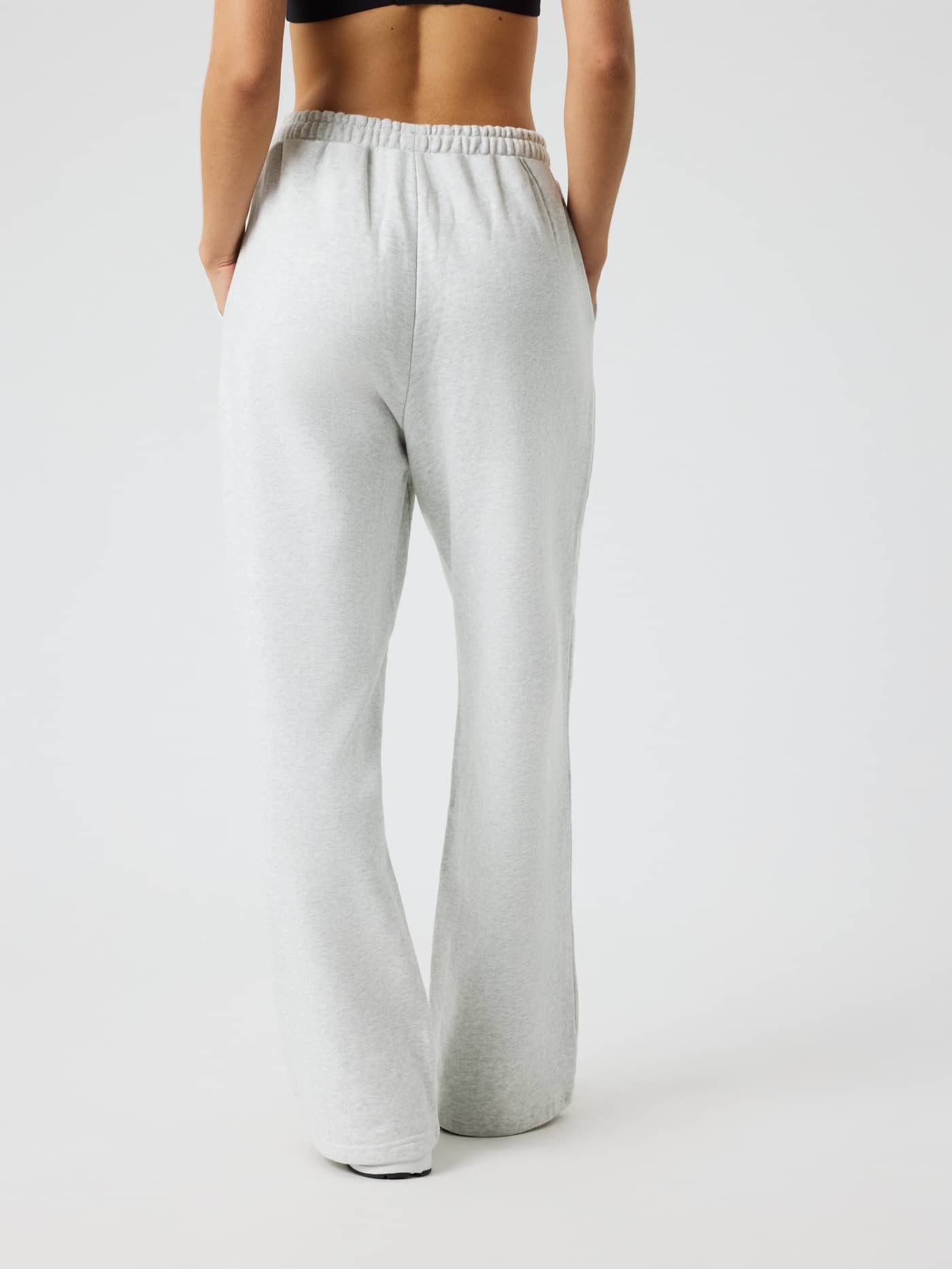 Back view of a model wearing the Studio Oversized Straight Sweatpants in Ultra Light Grey Melange (Grey). - Image 2