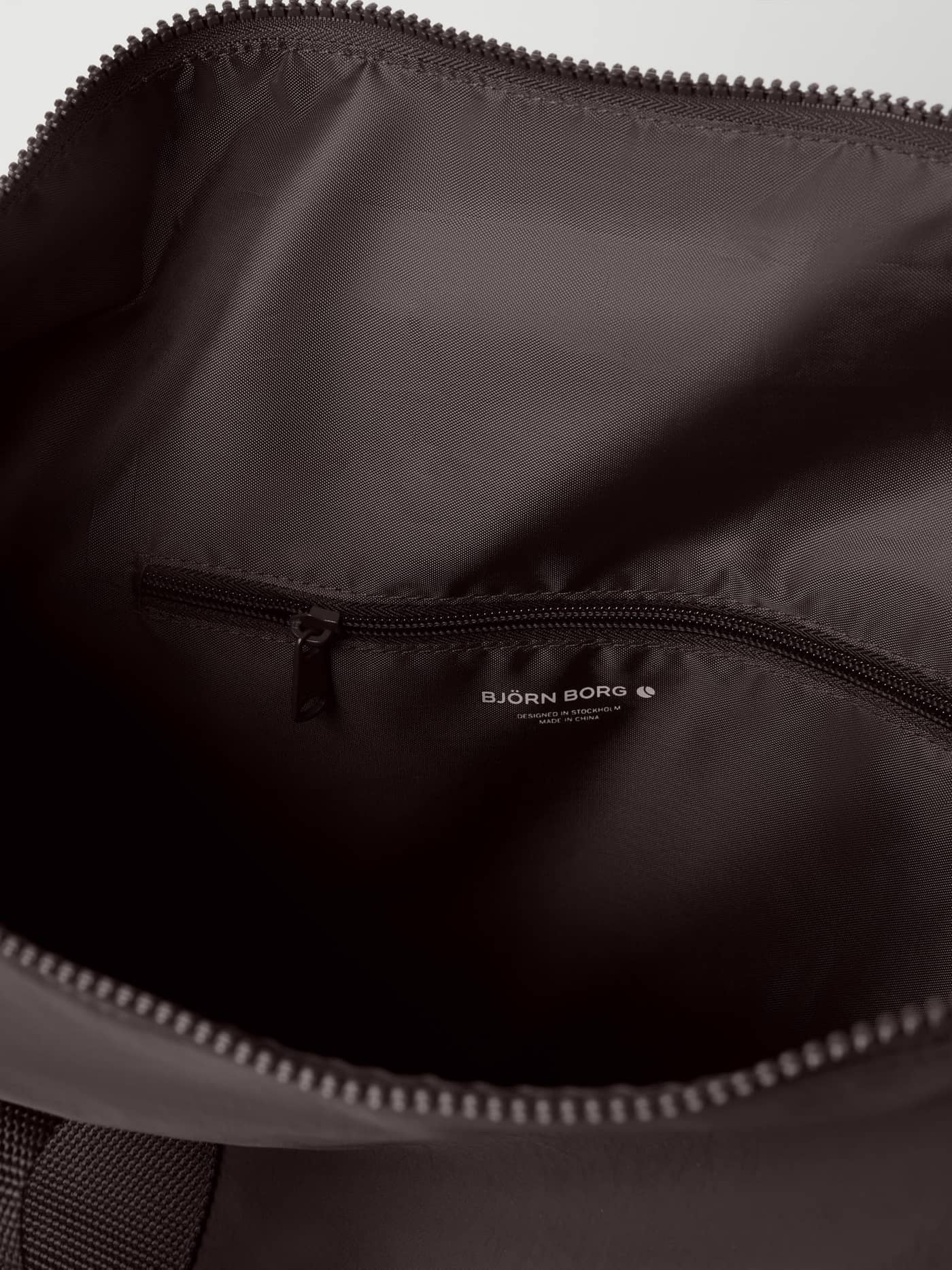 Studio Active Sports Bag 25L in Coffee Bean (Brown) interior featuring an internal zip pocket and white logo for training. - Image 4