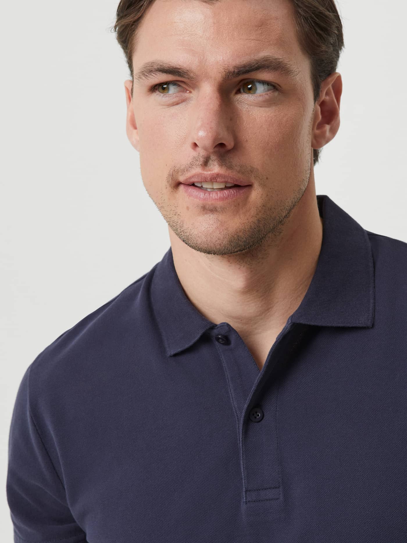 Close-up of a man wearing the Night sky (Navy) Borg Polo Shirt in cotton piqué, featuring a classic button placket. - Image 5