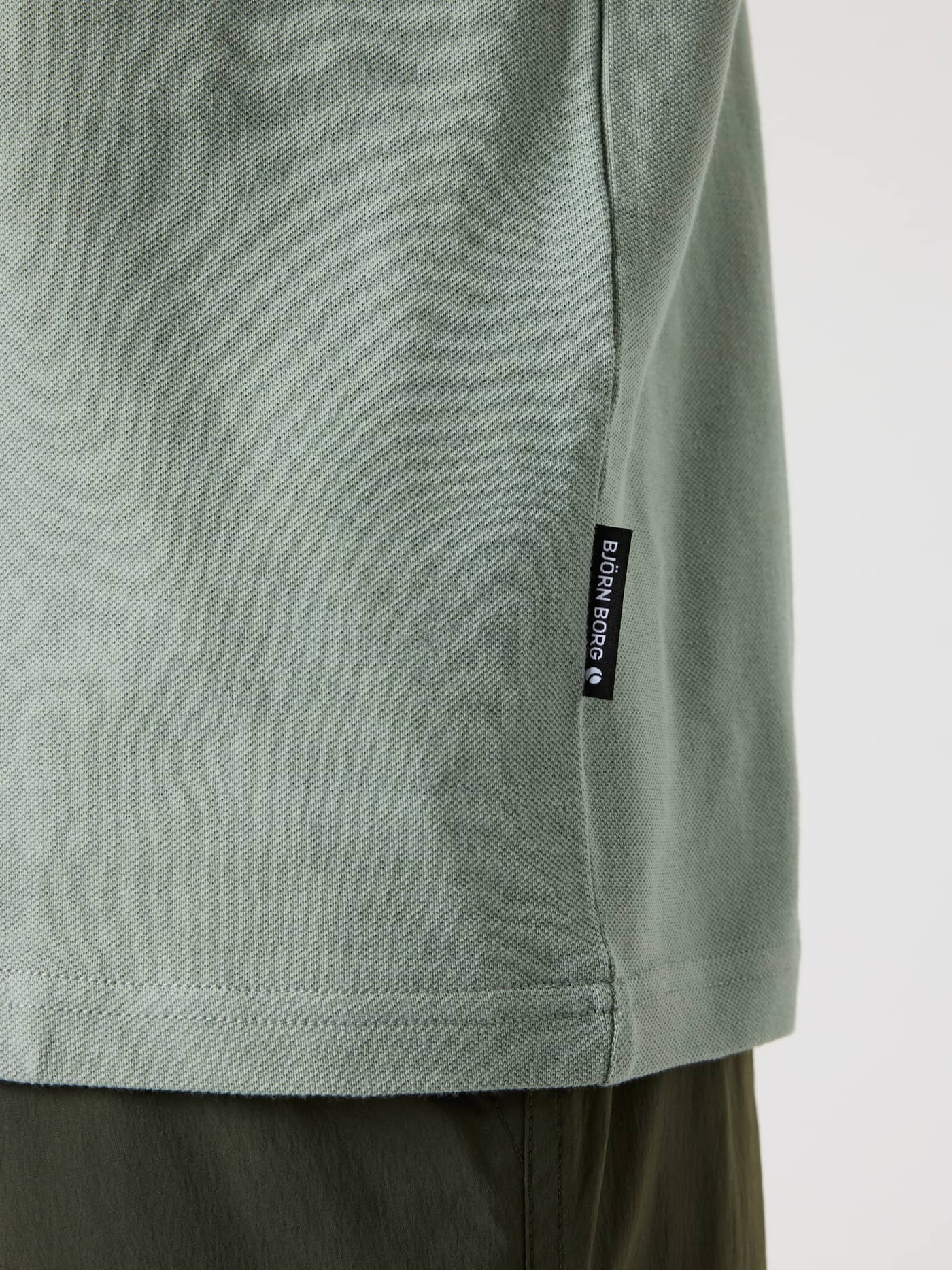 Borg Polo Shirt i Slate Gray (Grøn) i bomuldspiké med sort flag-label og hvidt logo vist i nærbillede. - Image 4