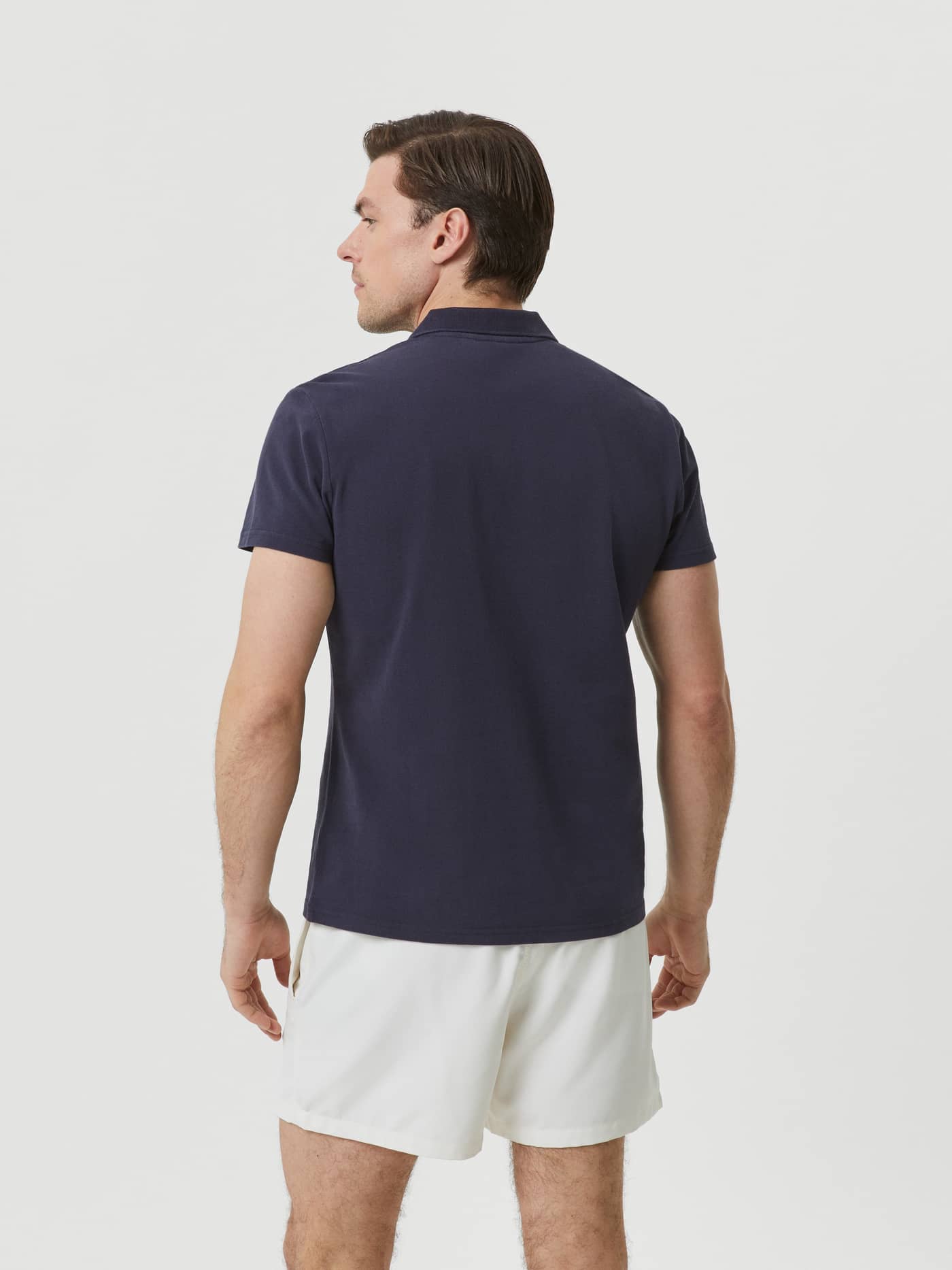 Back view of a man wearing a regular fit Borg Polo Shirt in Night sky (Navy) cotton piqué. - Image 2