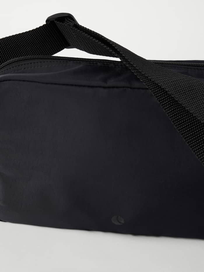 Detailopname van de Studio Active Crossover Bag in Black Beauty (Zwart) met een stevige schouderband en ton-sur-ton logo. - Image 3
