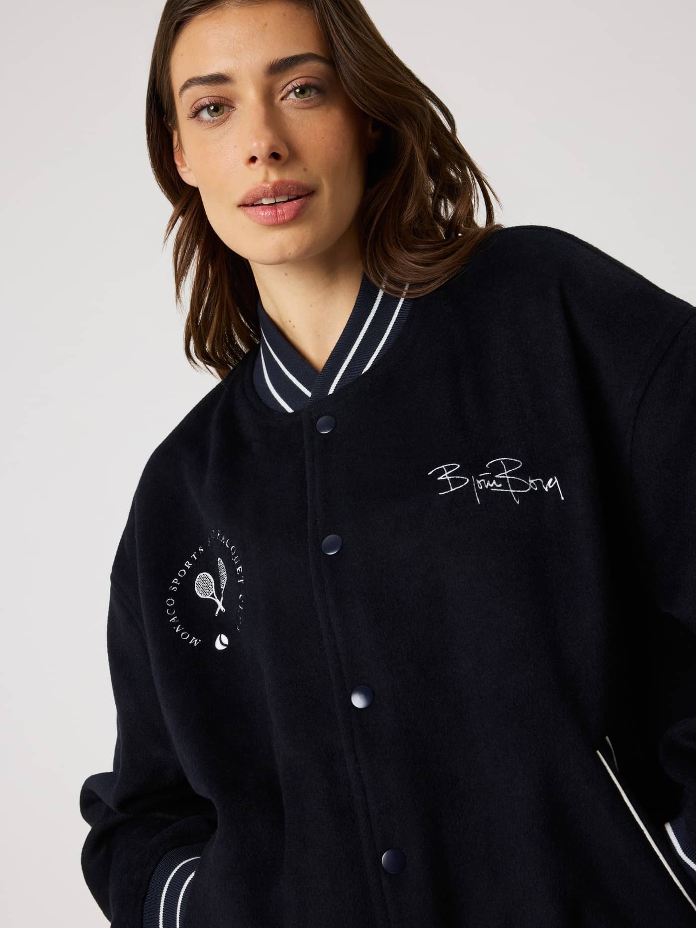 Femme portant la Borg Varsity Jacket en Night sky (Marine), avec une coupe oversized et une broderie tennis stylée. - Image 6