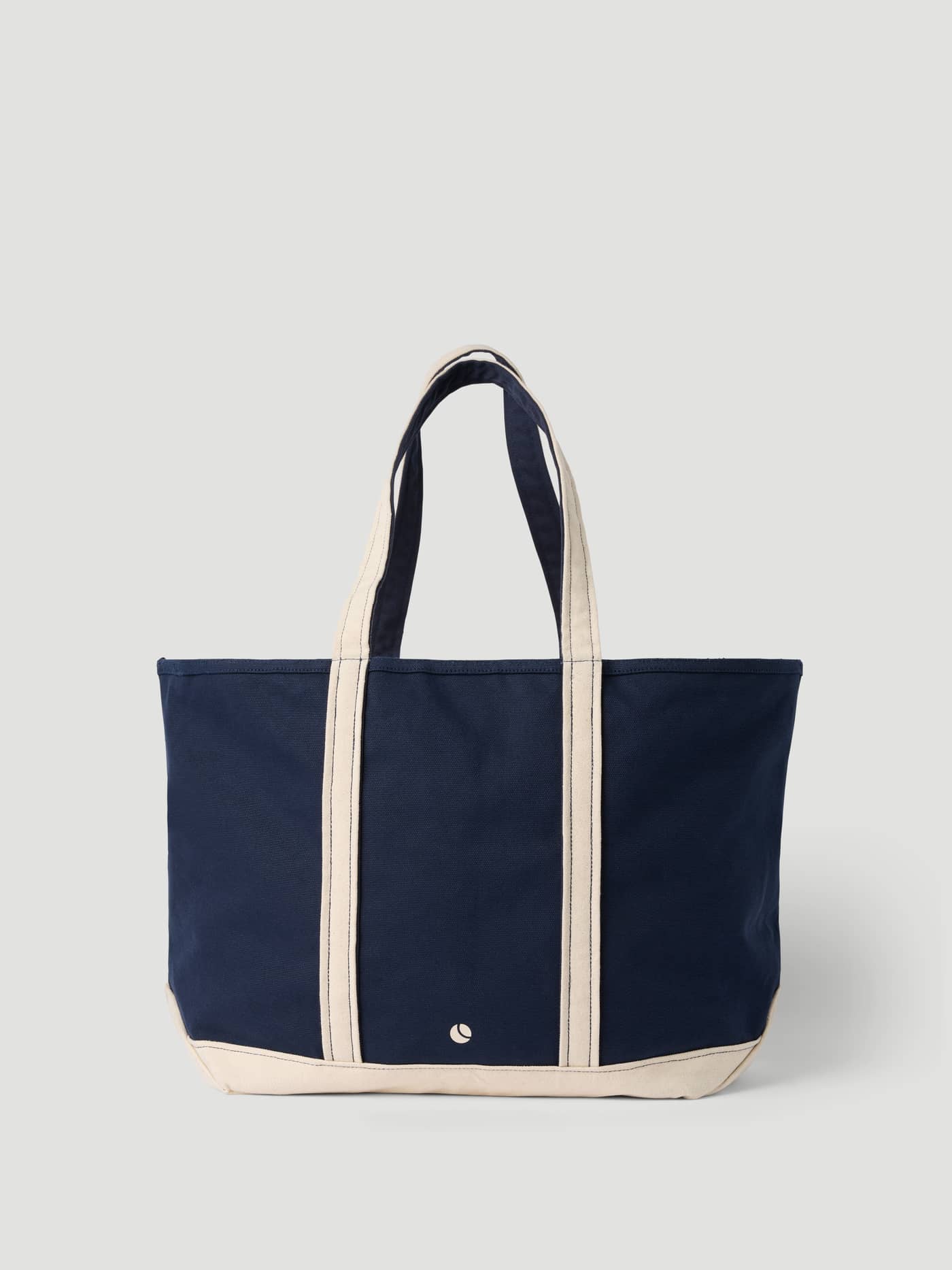 Vue de face du Ace Canvas Tote 30L en coton Night sky (Bleu marine) avec un petit logo de tennis blanc. - Image 5