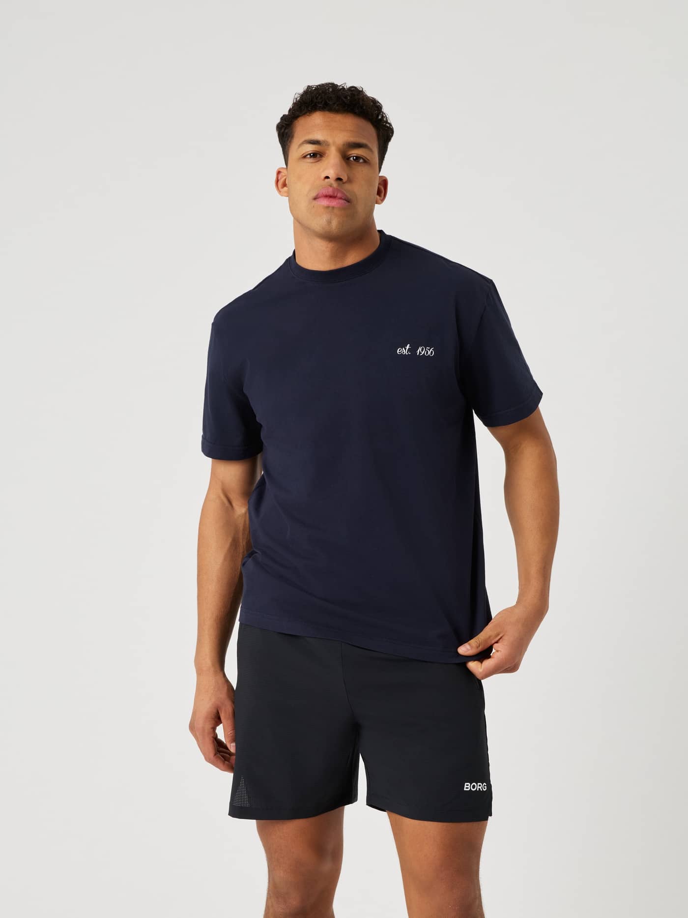Front view of a man wearing the Borg Classic Print T-Shirt in Night sky (Navy) with a white logo, for tennis style. - Image 2