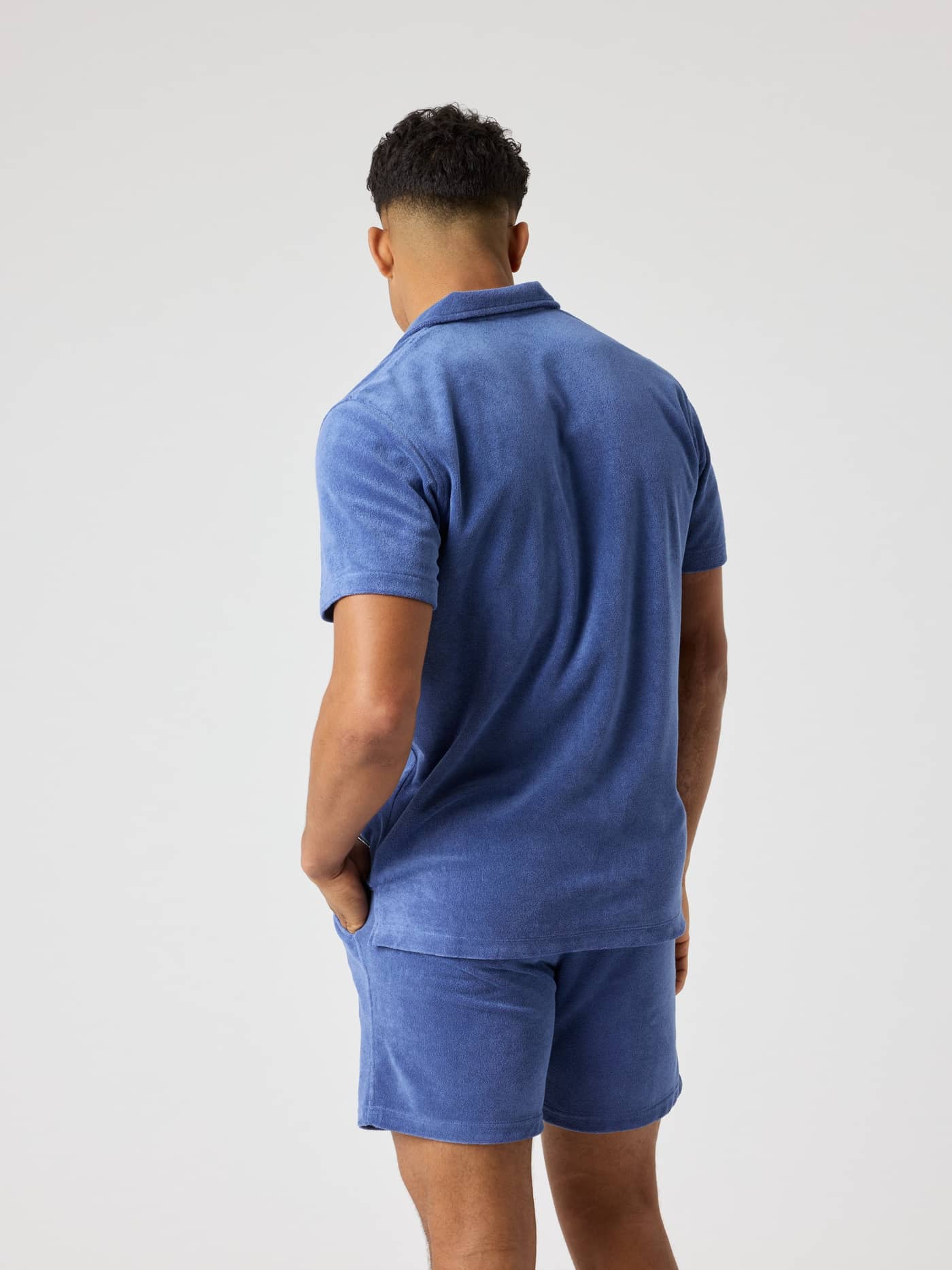 Back view of a man wearing the Borg Toweling Pool Shirt in Coastal Fjord (Blue), with a regular fit and soft terry fabric. - Image 2