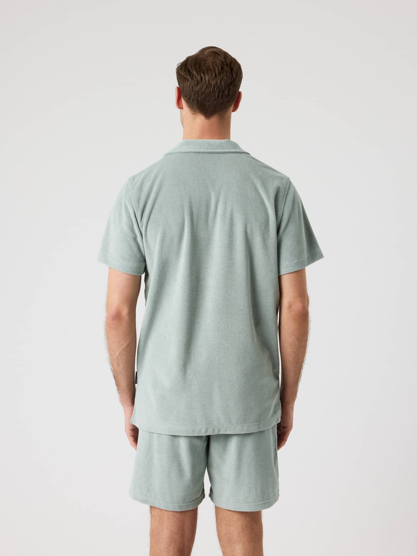 Back view of a man wearing the regular-fit Borg Toweling Pool Shirt in Slate Gray (Green) in soft terry toweling. - Image 2