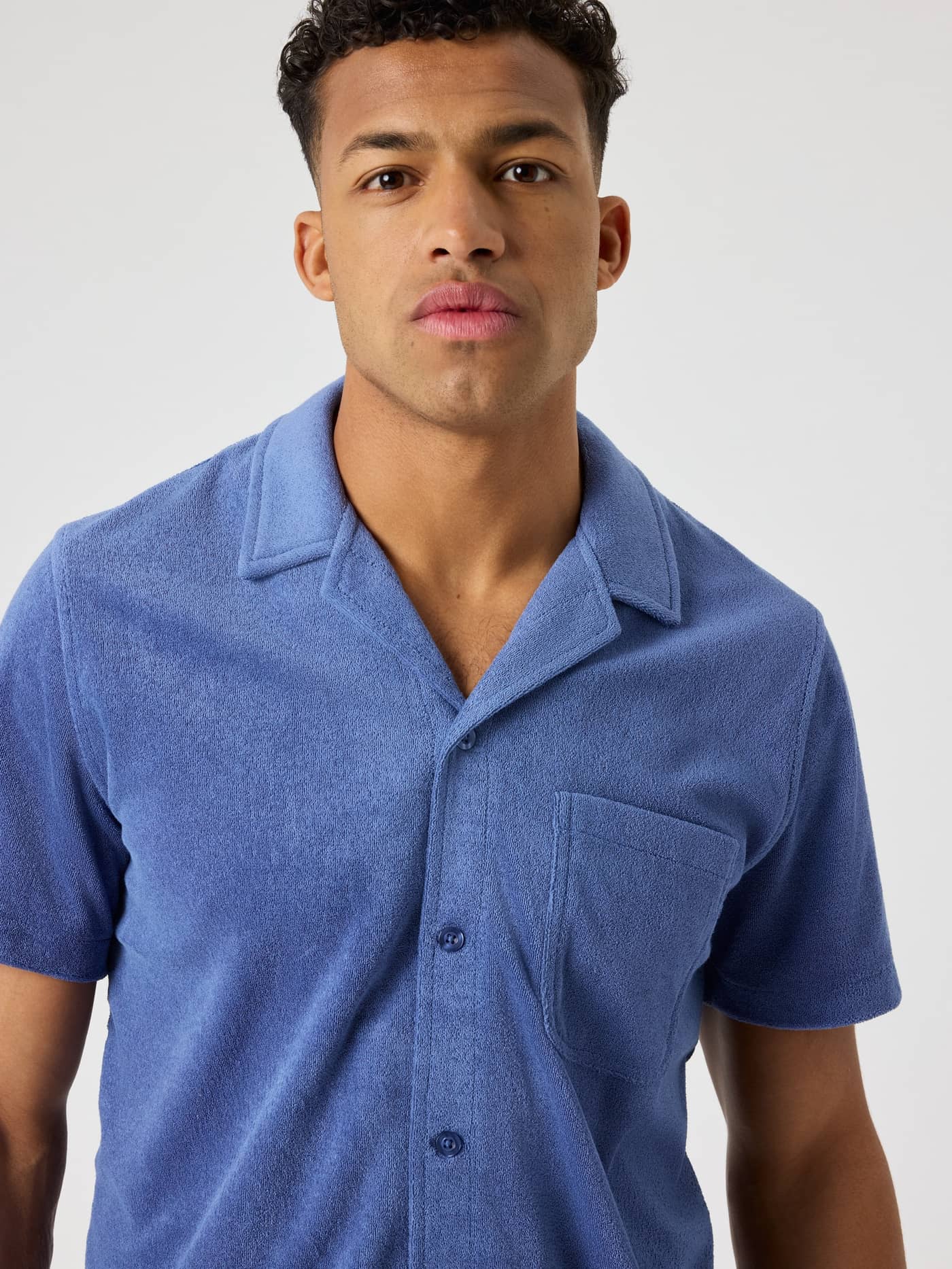 Close-up of the Björn Borg Toweling Pool Shirt in Coastal Fjord (Blue), featuring a relaxed camp collar and pocket. - Image 4