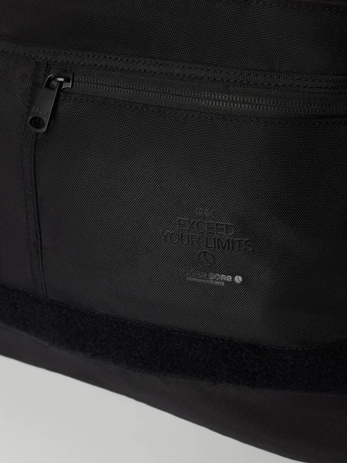 Gros-plan du Core Flapbag 12,5L en Black Beauty (Noir) en polyester recyclé avec logo noir et fermeture éclair. - Image 3