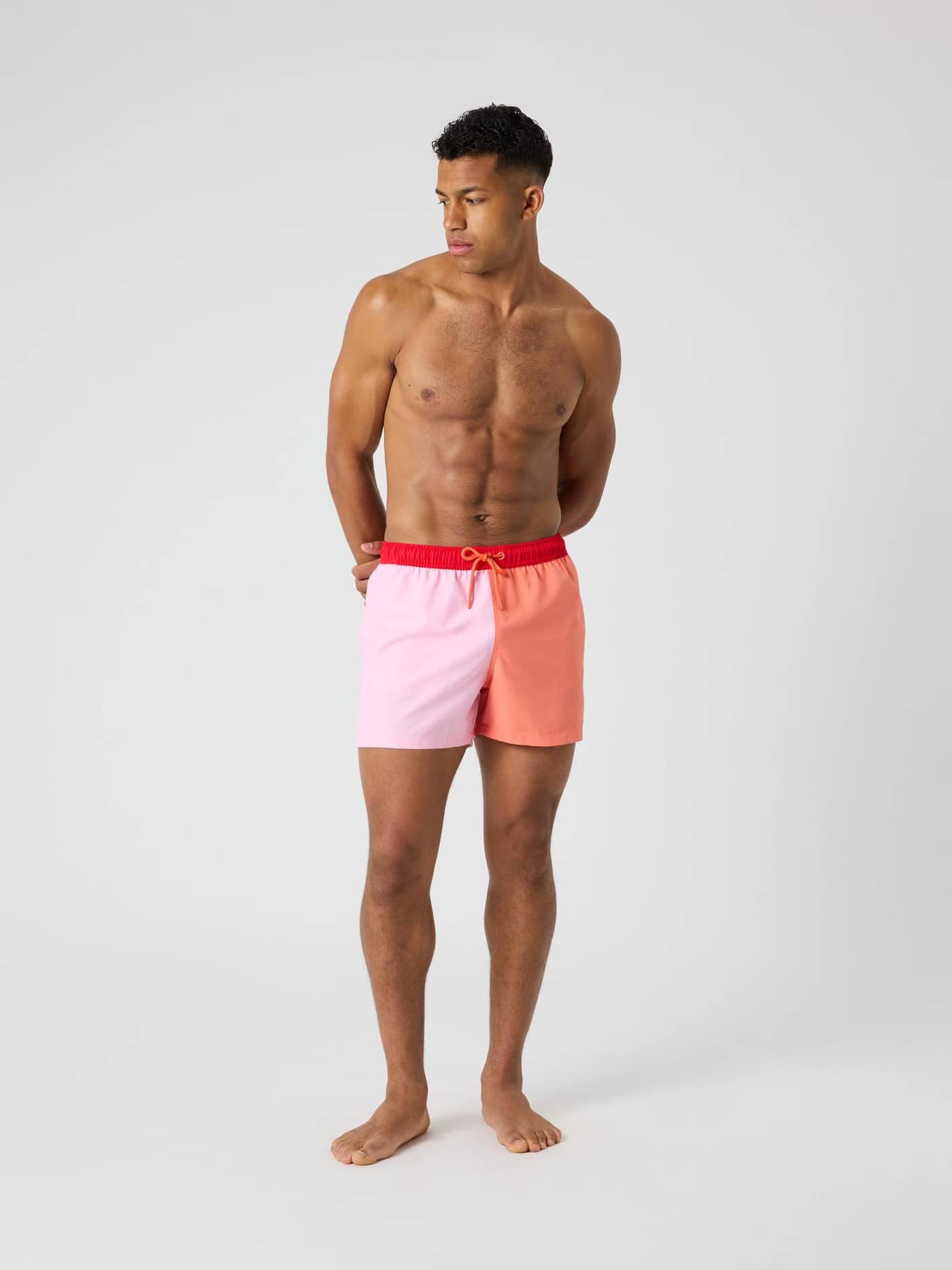 Full-body front view of a man wearing the Borg Blocked Swim Shorts in Candy Pink (Pink) for style and function. - Image 3