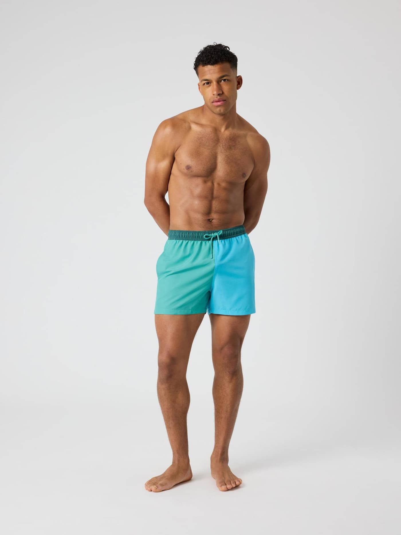 Full-body front view of a man in color-blocked Borg Blocked Swim Shorts by Björn Borg in Sea Blue (Blue) with a regular fit. - Image 3