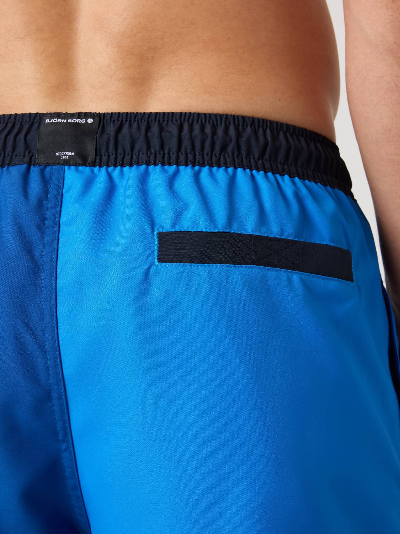 Close-up back view of the Borg Blocked Swim Shorts in Palace Blue (Blue), showing the logo label and back pocket. - Image 5