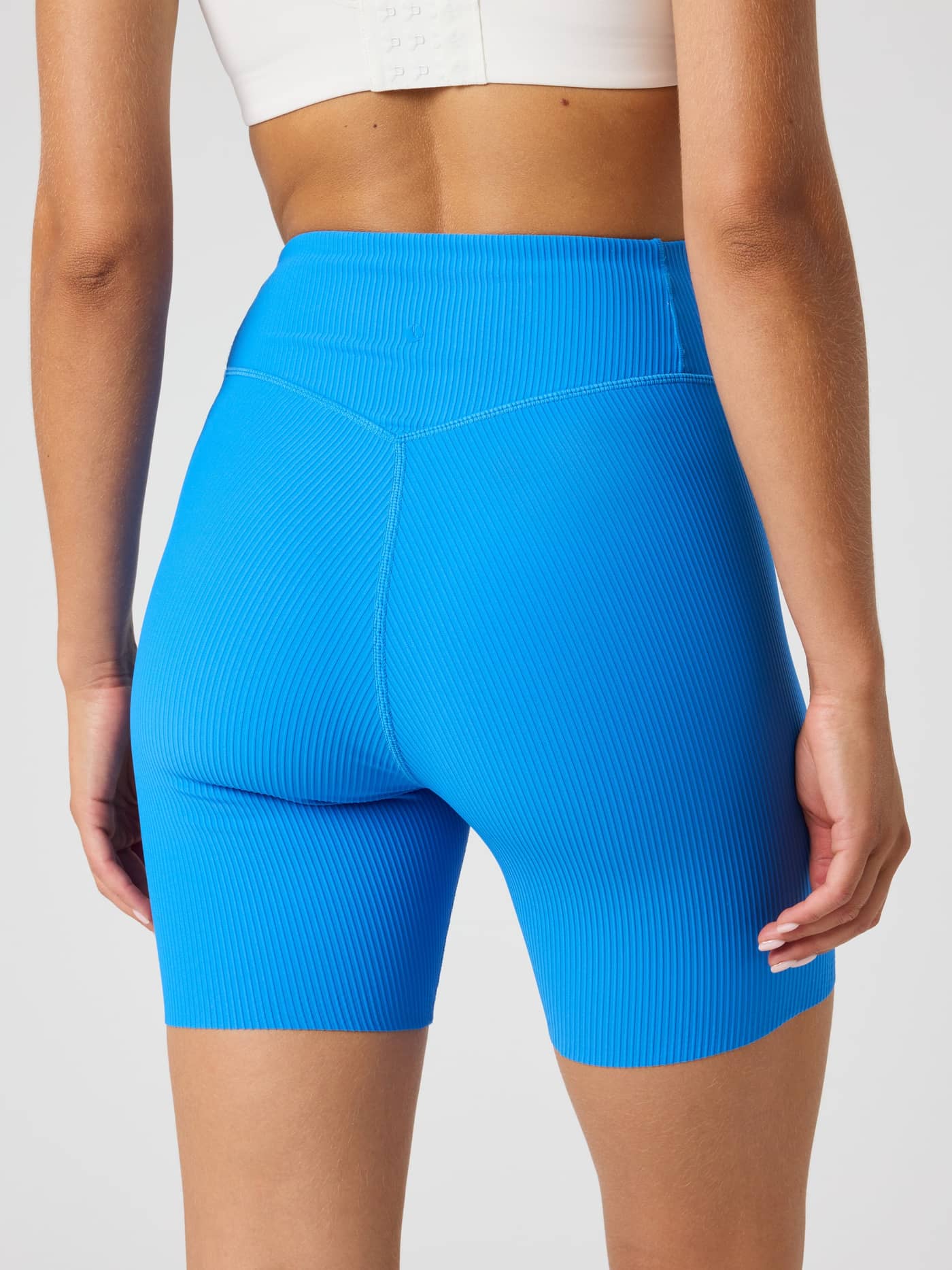 Back view of a model wearing high-waisted Björn Borg Studio Ribbed Shorts in Palace Blue (Blue) for a training fit. - Image 2