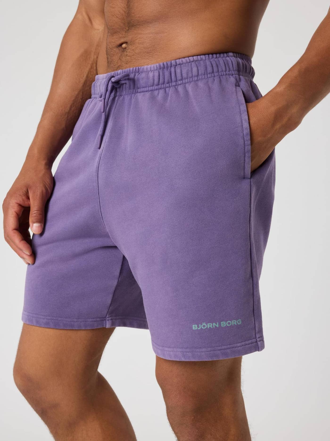 Borg Classic Sweatshorts en Mystical (Morado) en un hombre con logo verde menta y un elegante ajuste de algodón. - Image 4