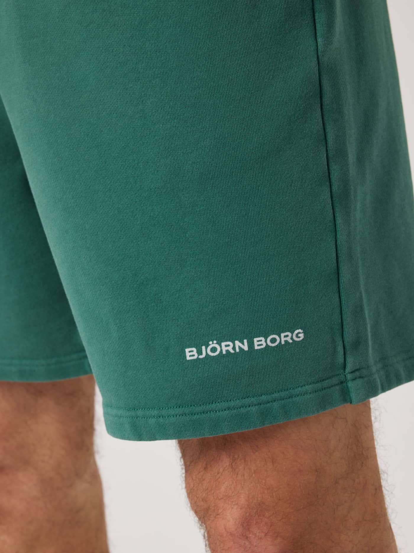 Primer plano de los Borg Classic Sweatshorts en Mallard Green (Verde) con el logo blanco estampado en la pierna. - Image 4