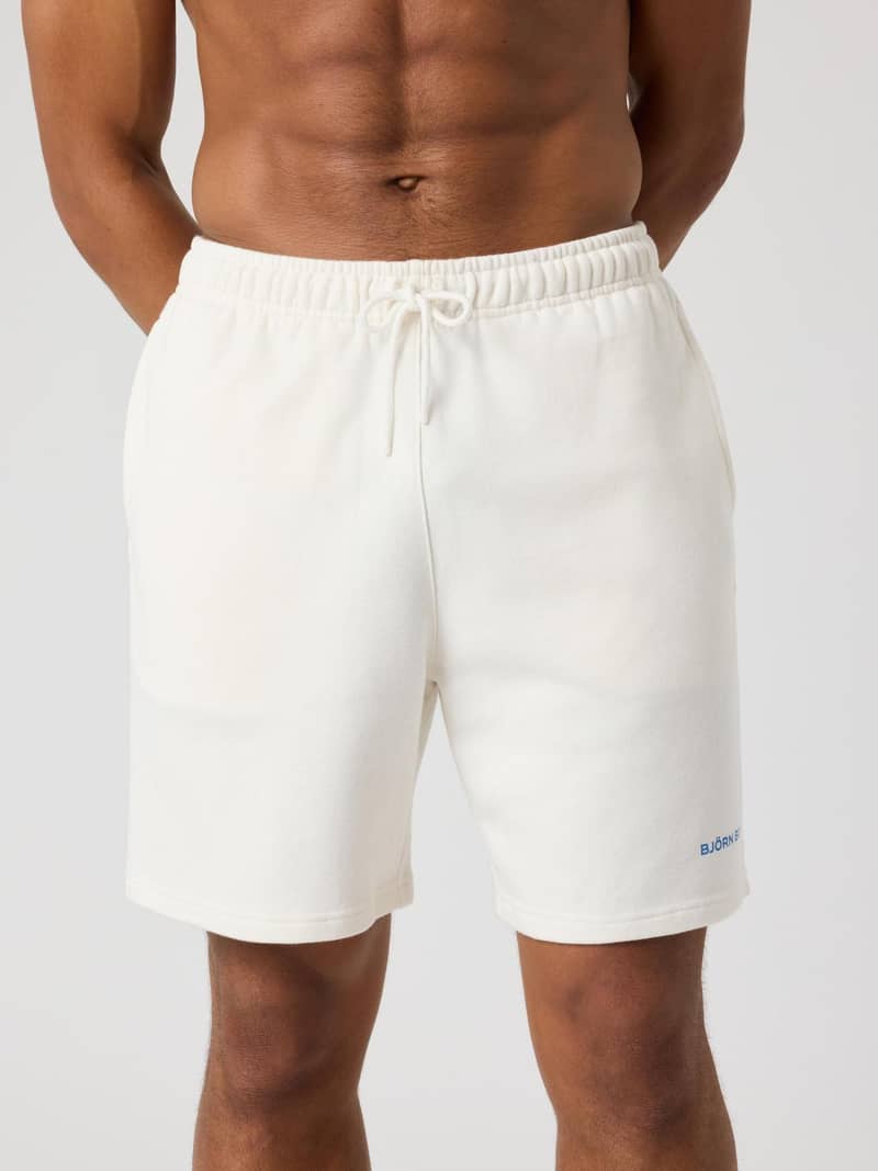 Borg Classic Sweatshorts i Tofu (Vit) sedda framifrån på en man, i mjuk french terry i bomull med en blå logotyp.