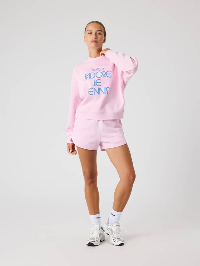 Ganzkörper-Vorderansicht einer Frau im oversized Borg Boyfriend Sweatshirt in Pink Lady (Rosa) mit Tennis-Grafik. - Image 3