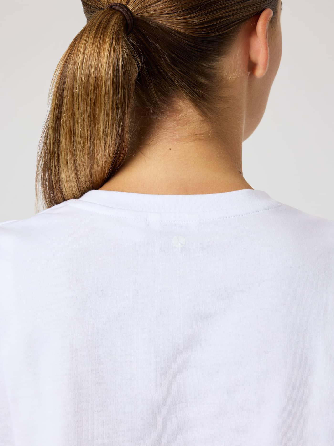 Close-up back view of the Borg Cotton T-Shirt in Brilliant White (White) featuring a tennis ball print at the neck. - Image 5