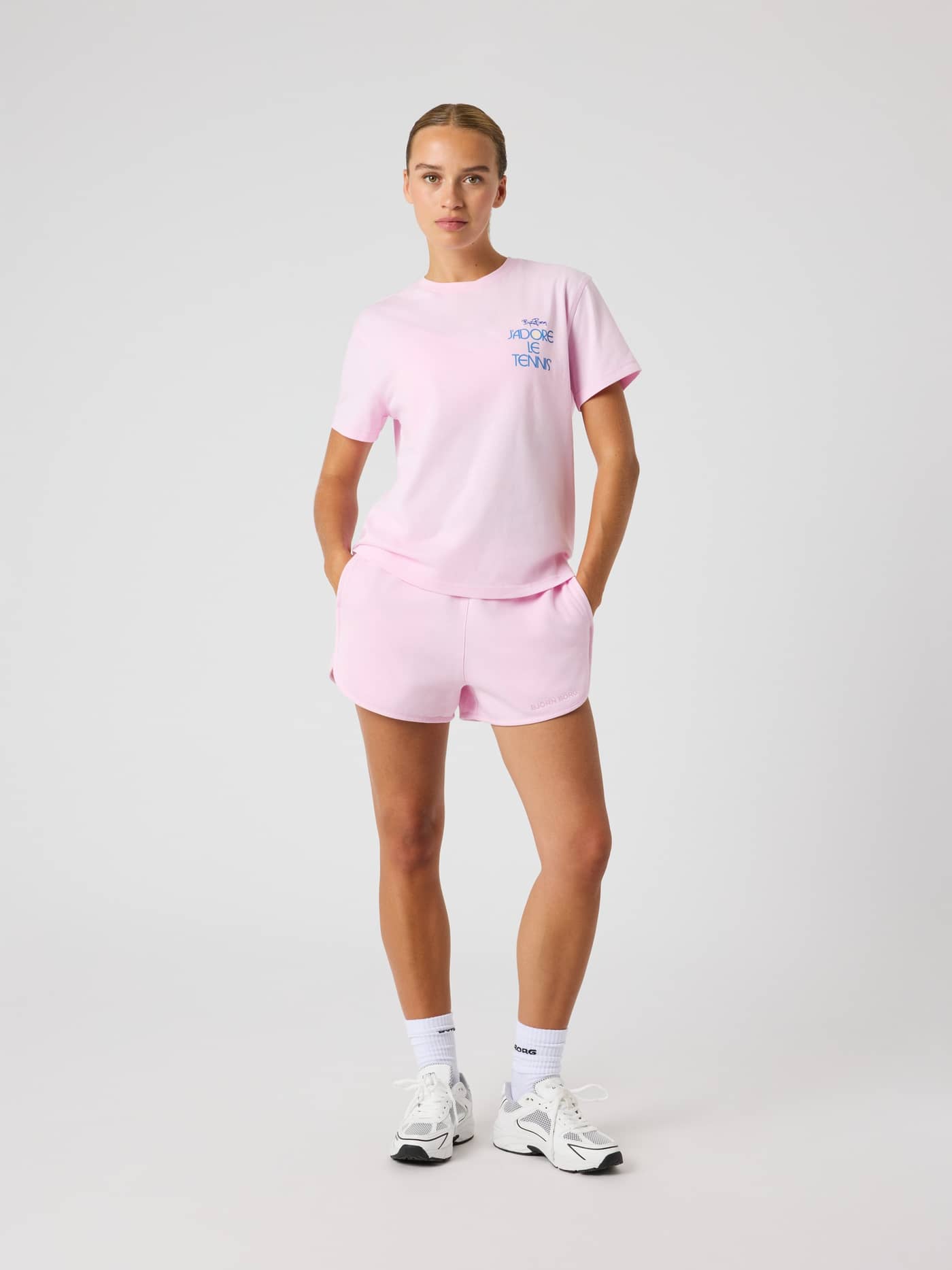 Full-body front view of a woman in the 100% cotton Borg Cotton T-Shirt in Pink Lady (Pink) with a stylish tennis graphic. - Image 3