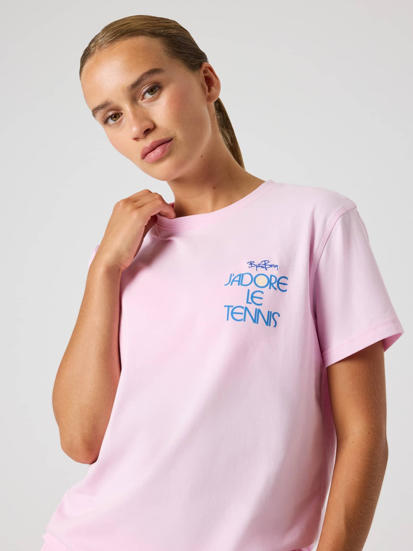 Front view of a model wearing the Borg Cotton T-Shirt in Pink Lady (Pink), featuring a blue tennis chest graphic. - Image 4
