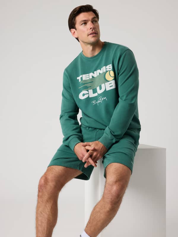 Vue de face d'un homme en Borg Classic Print Sweatshirt Mallard Green (Vert) avec un graphique de tennis blanc et jaune.
