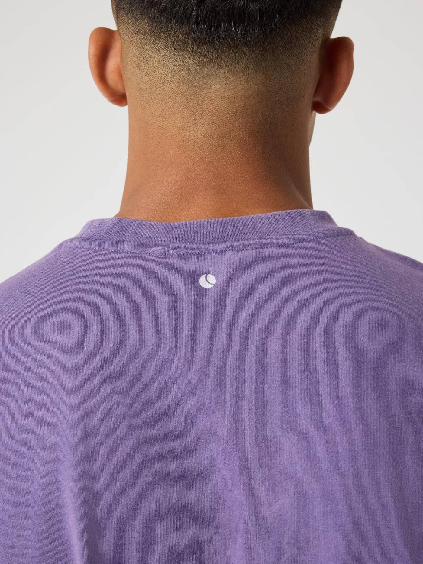 Back neck detail of the Borg Classic Print T-Shirt in Mystical (Purple) featuring a white tennis ball logo. - Image 4