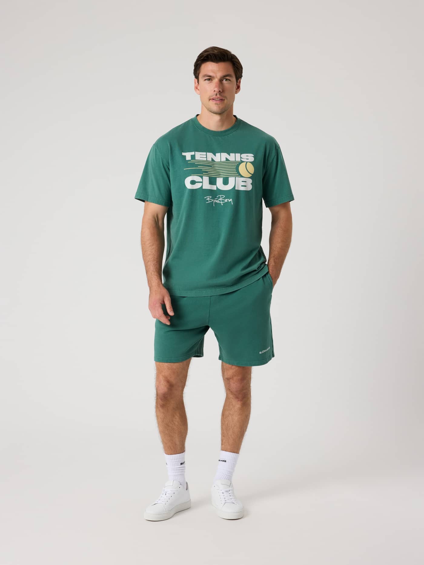 Full-body front view of a man in the cotton Mallard Green (Green) Borg Classic Print T-Shirt with a tennis club graphic. - Image 3