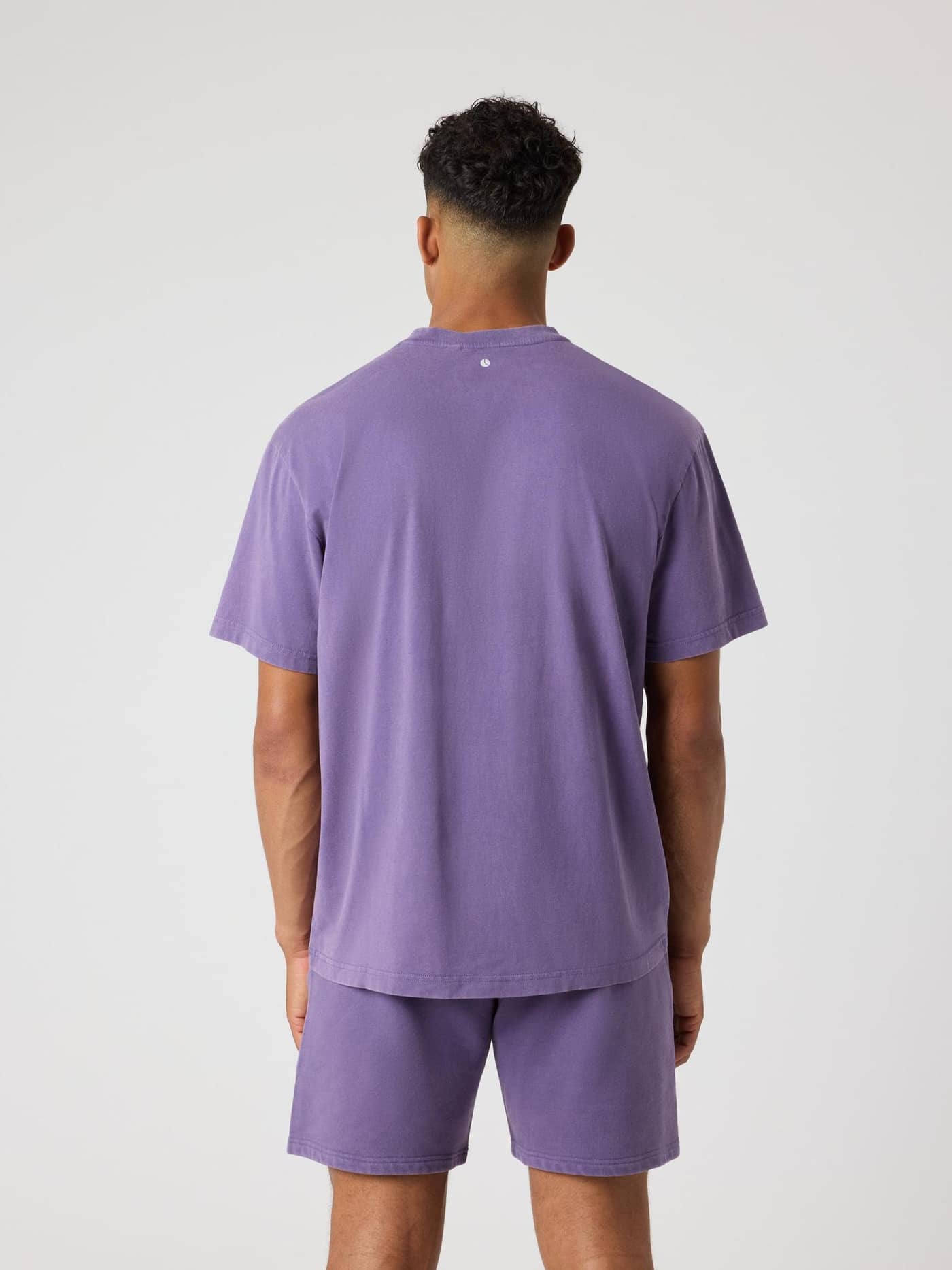 Back view of a man wearing the Borg Classic Print T-Shirt in Mystical (Purple) with a tennis ball detail. - Image 2