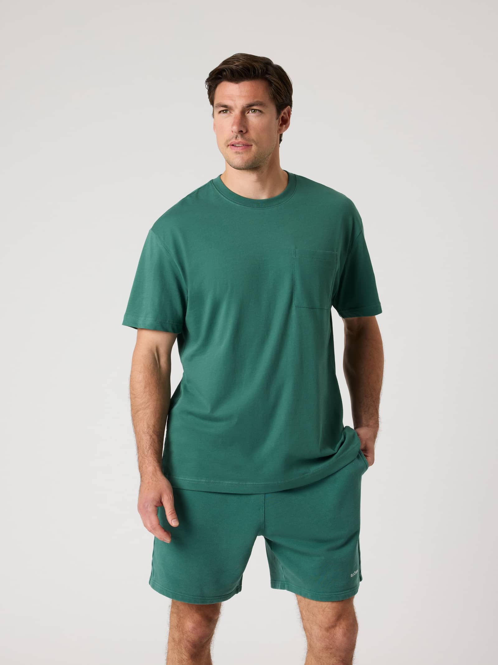 Mallard Green Borg Relaxed T-shirt met borstzakje en bijpassende short gedragen door een man in vooraanzicht. - Image 1