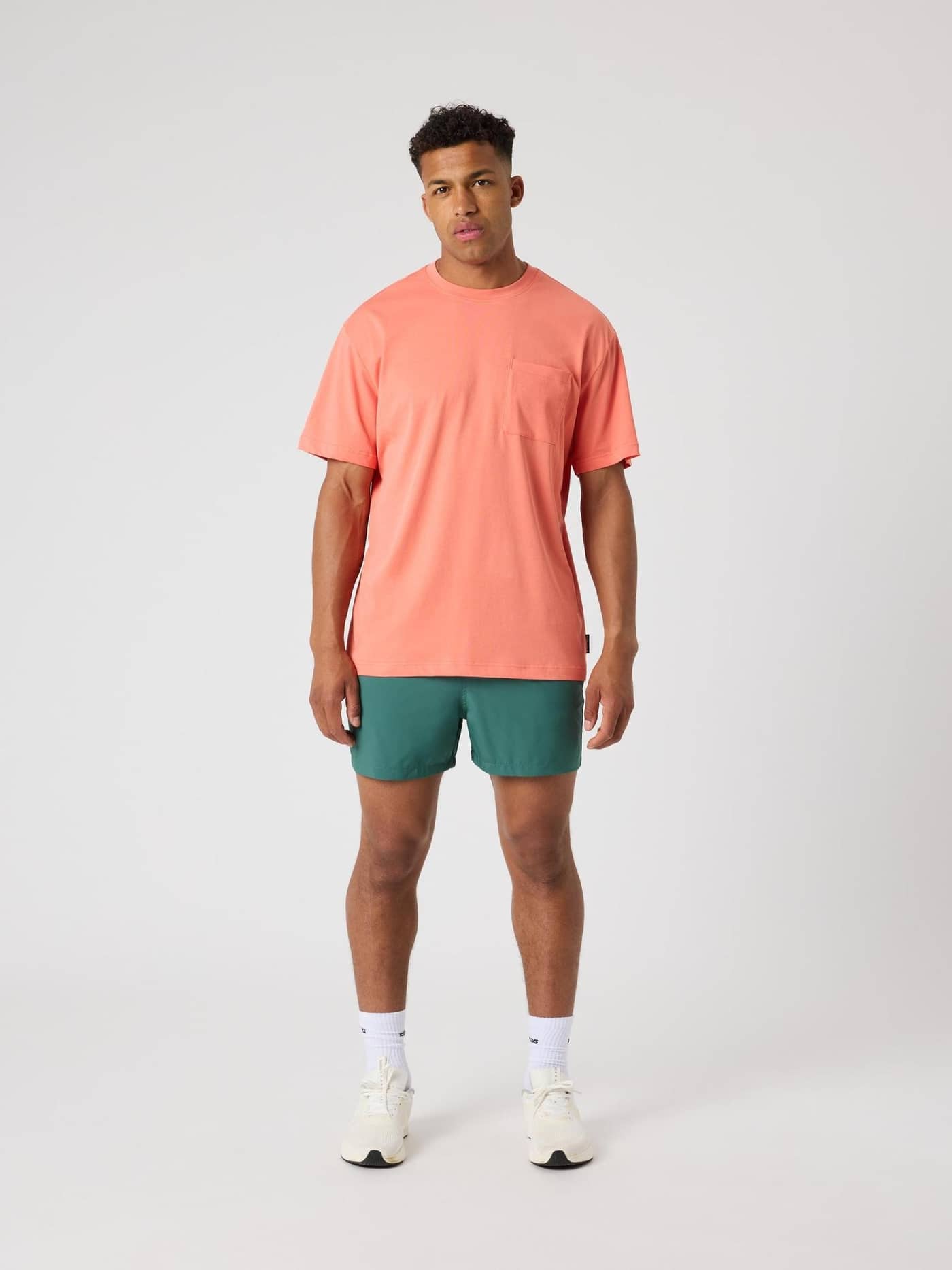 Vooraanzicht van een man in het Borg Relaxed T-Shirt in Coral (Oranje) met een borstzak en relaxte pasvorm. - Image 3