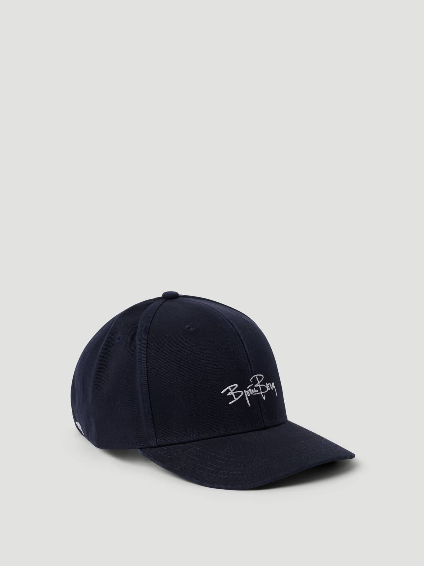 Borg Signature Cap i Night sky (Marinblå) snett från sidan med Björn Borg-signaturbrodering i ekologisk bomull för tennis. - Image 1
