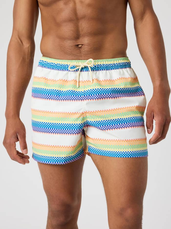 Front view of a man wearing the Borg Print Swim Shorts in a multi-coloured blue, yellow, and orange pixel stripe.