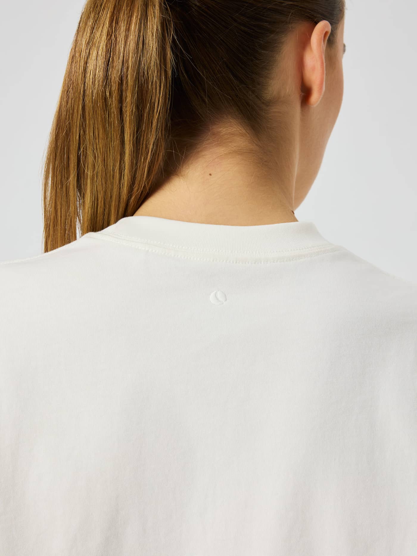 Gros plan arrière de la Studio Oversized T-Shirt Dress en coton Tofu (Blanc) avec imprimé balle de tennis. - Image 5