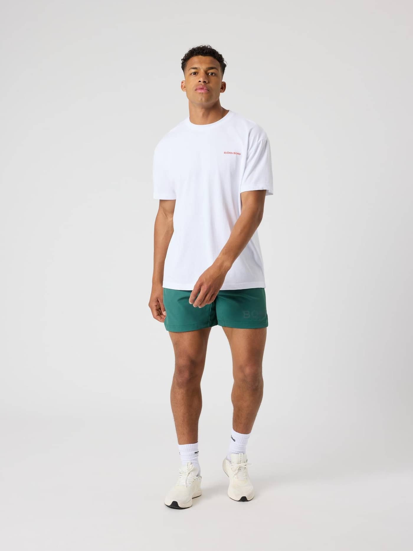 Vorderansicht eines Mannes im Borg Gym Pride Oversized T-Shirt in Brilliant White (Weiß) mit rotem Logo für das Training. - Image 4