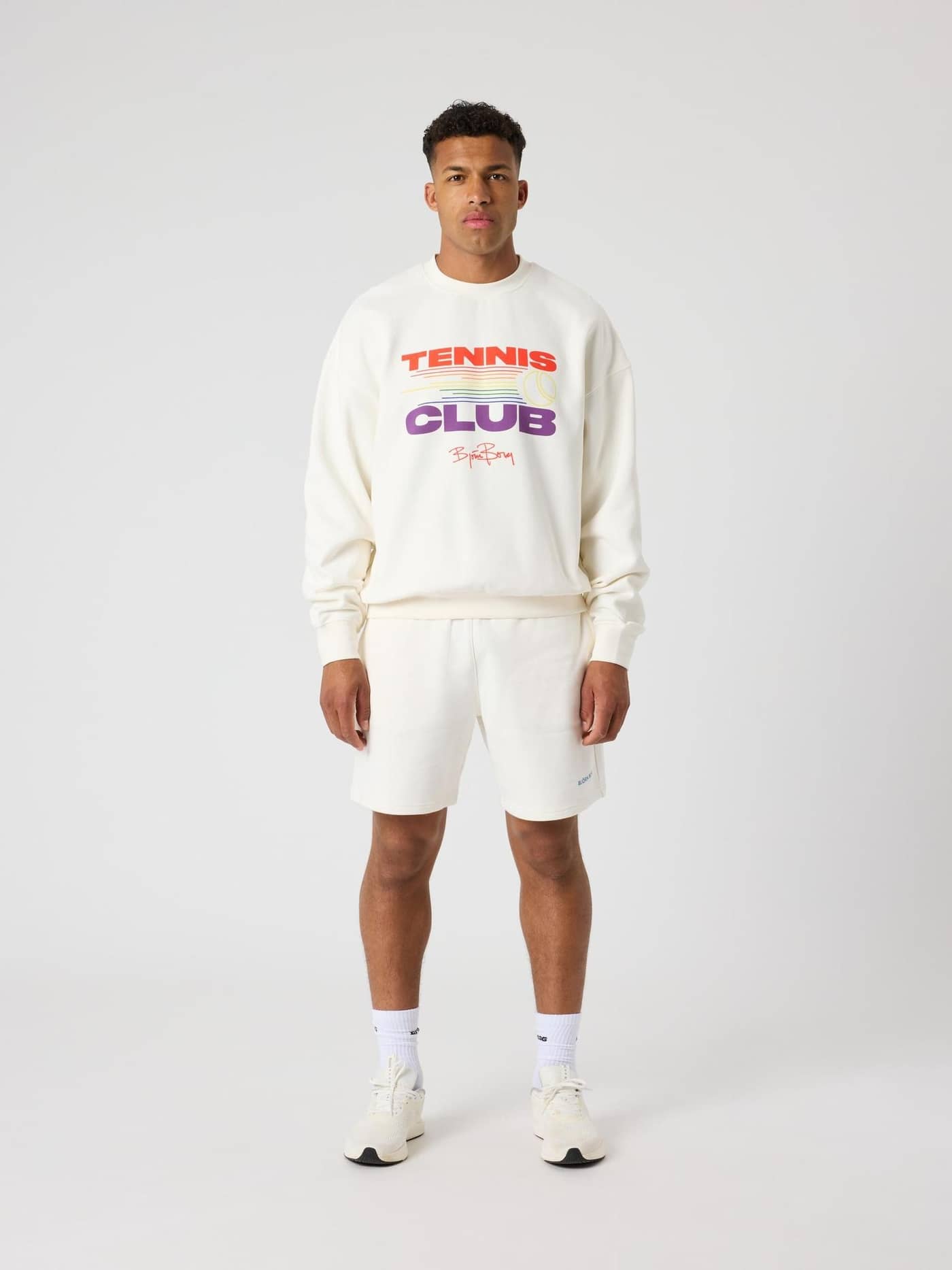 Borg Oversized Pride Sweatshirt i Tofu (Vit) sedd framifrån i helfigur på en man med ett grafiskt tennistryck. - Image 3